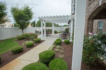 A patio with a white pergola and a white pillar.